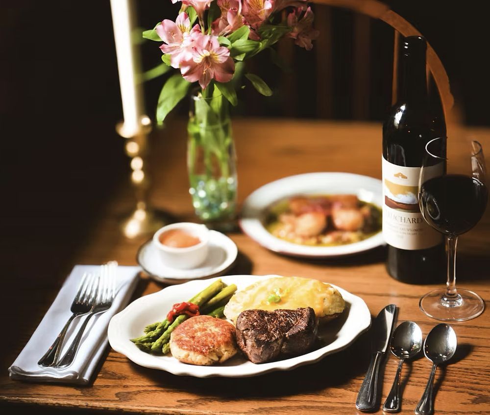 Photo of plates on a table, with steak, shrimp, asparagus and more