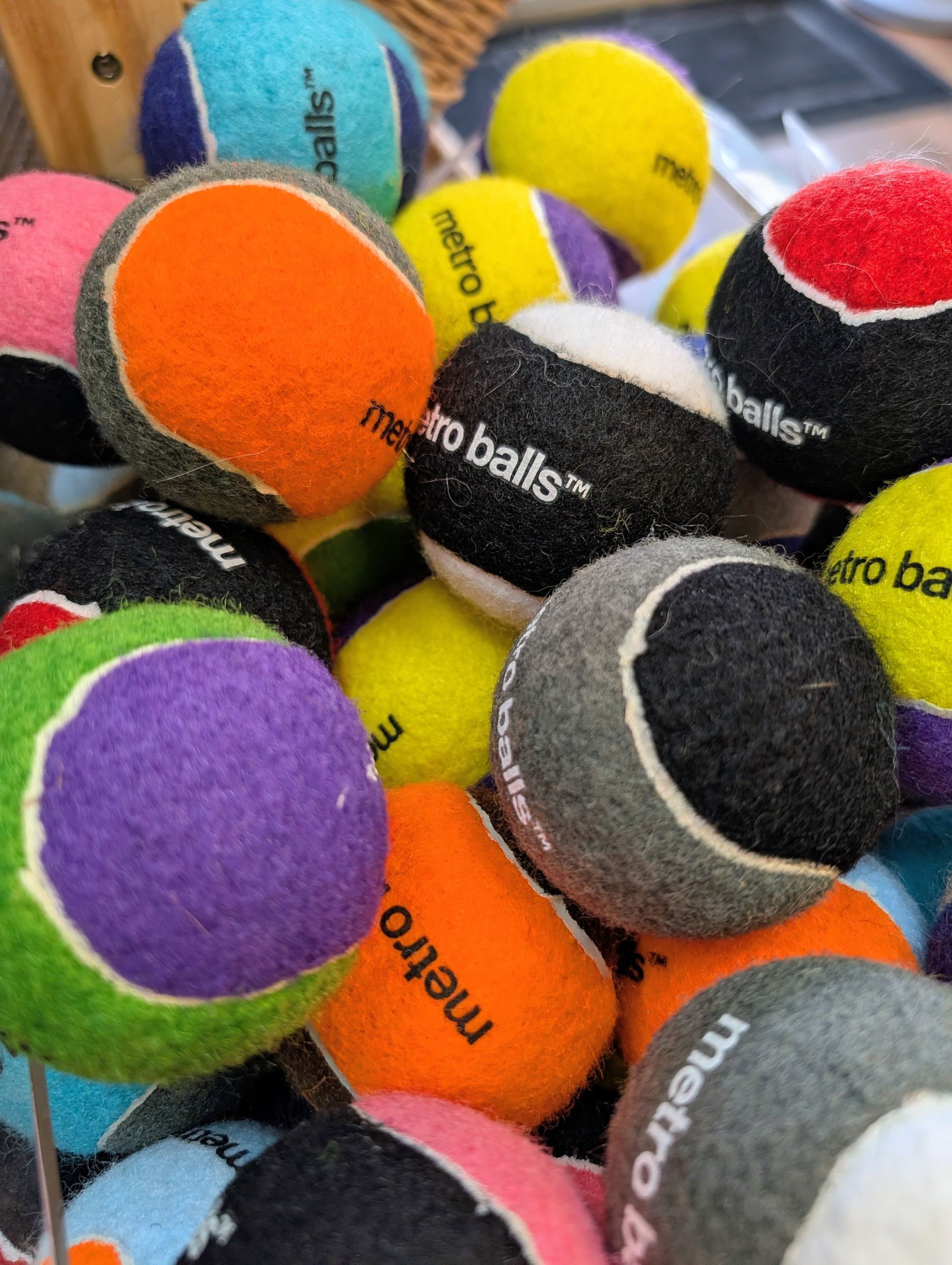 Pile of multi-colored tennis balls, some with