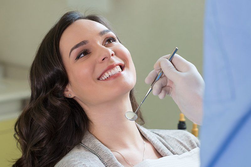 dentista esaminando i denti di una giovane donna