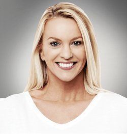 Blonde woman smiles, wearing a white shirt, with a gray background.