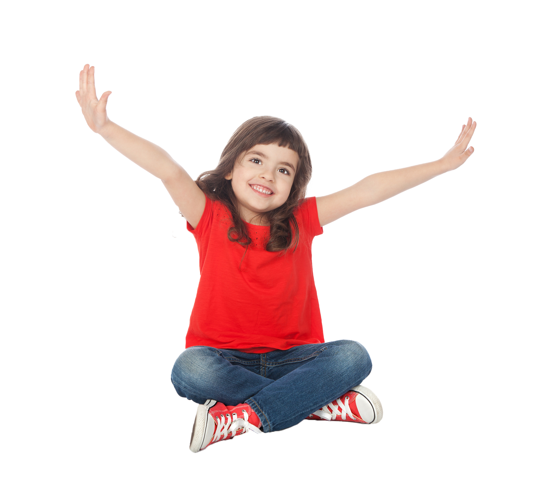Young girl with arms raised, smiling, in a red shirt and jeans. Girl in red shirt and jeans sits cross-legged with arms outstretched, smiling.