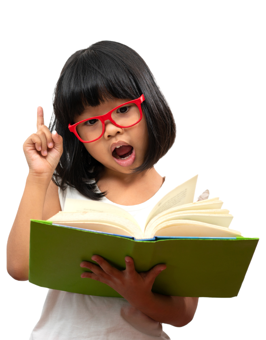Girl with red glasses points up while reading a green book, mouth open, expressing excitement.