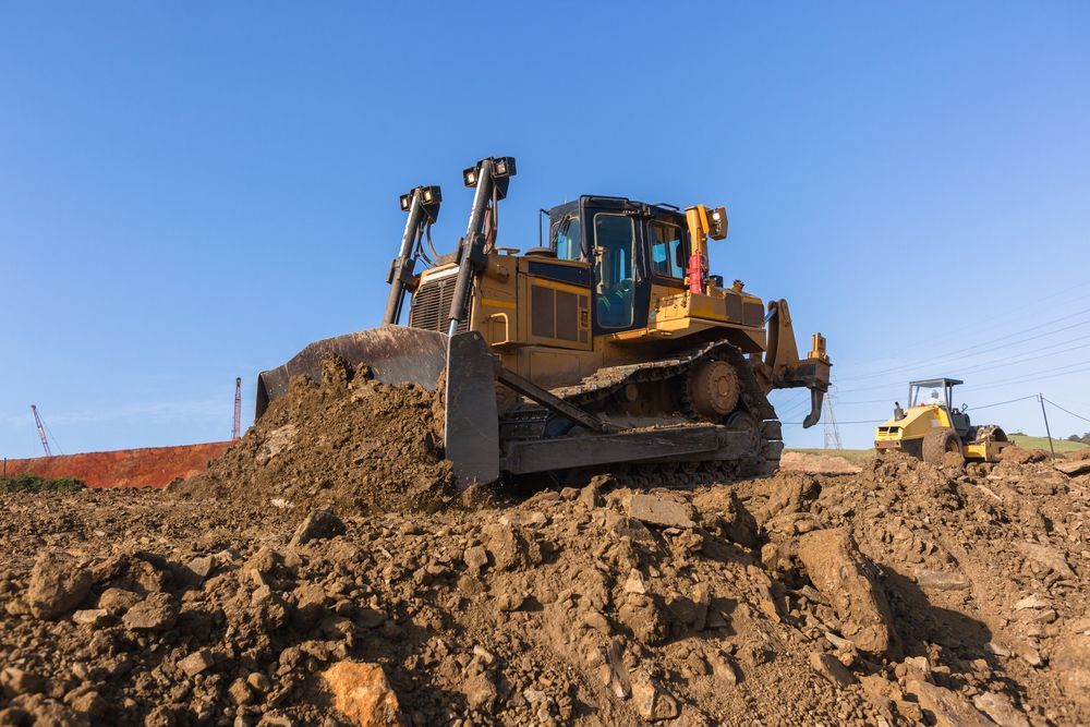 A Bulldozer Is Moving Dirt In A Muddy Field — Territory Industries Pty Ltd In Uralla, NT