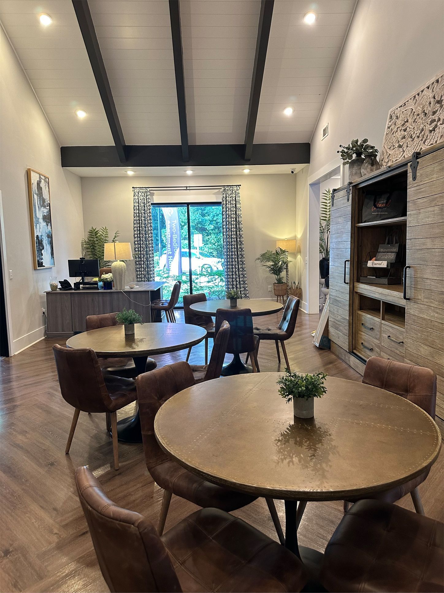 There are many tables and chairs in the room.