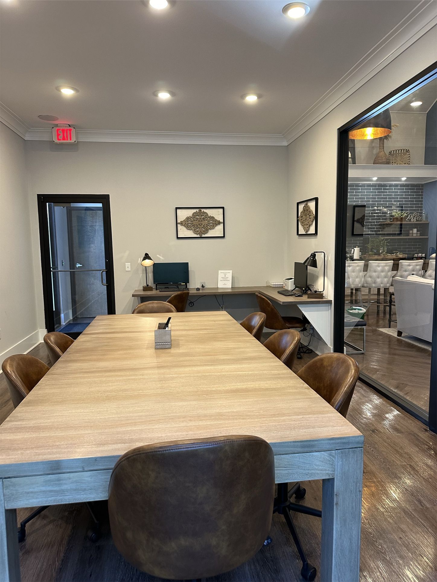 A conference room with a long wooden table and chairs.