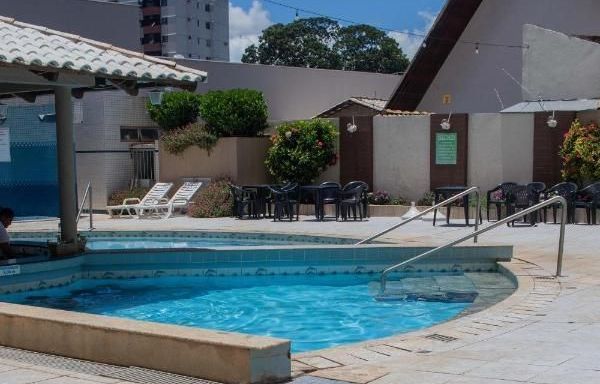 Uma grande piscina com cadeiras e mesas ao redor