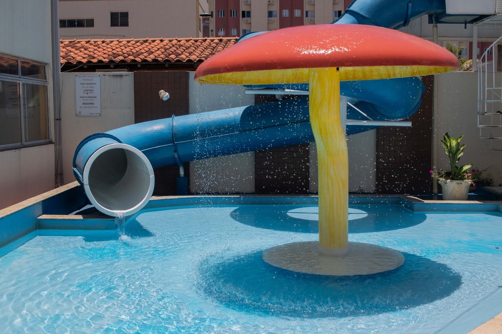 Uma roda gigante está no meio de um parque de diversões.