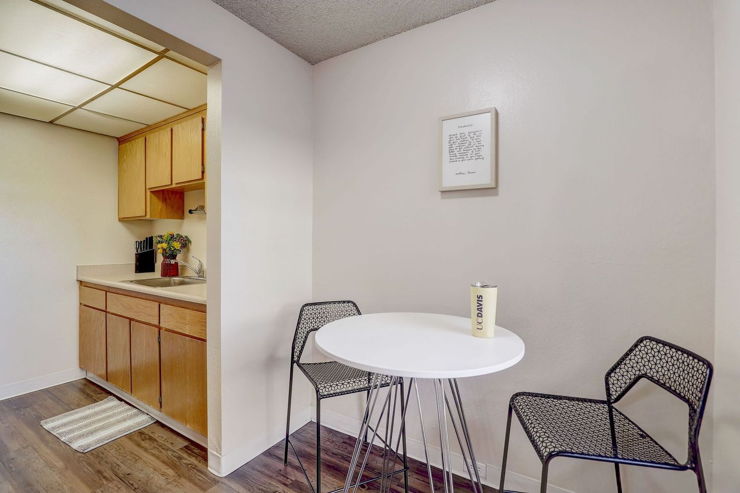 A kitchen with a table and chairs and a picture on the wall