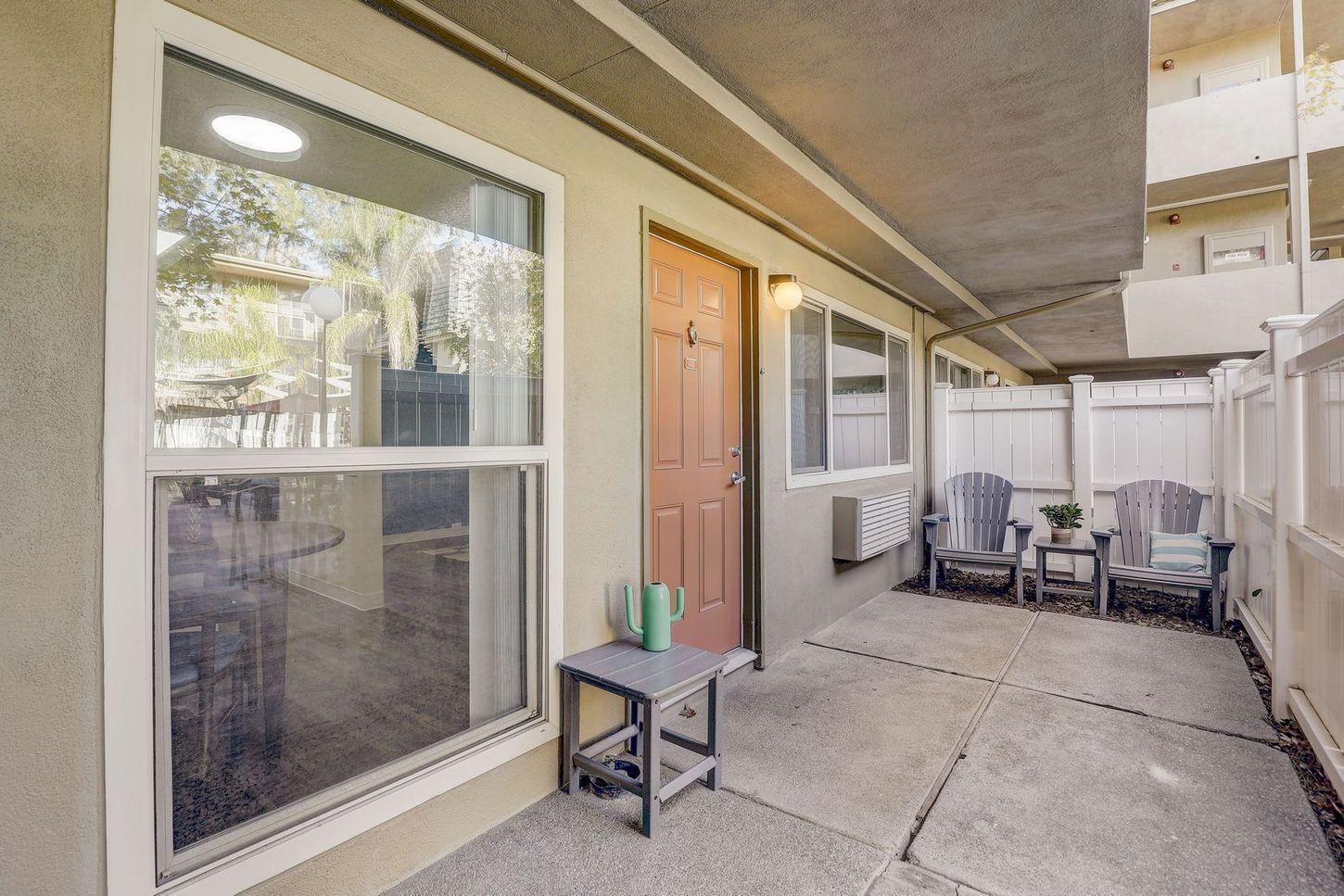 A patio with chairs and a table in front of a house.