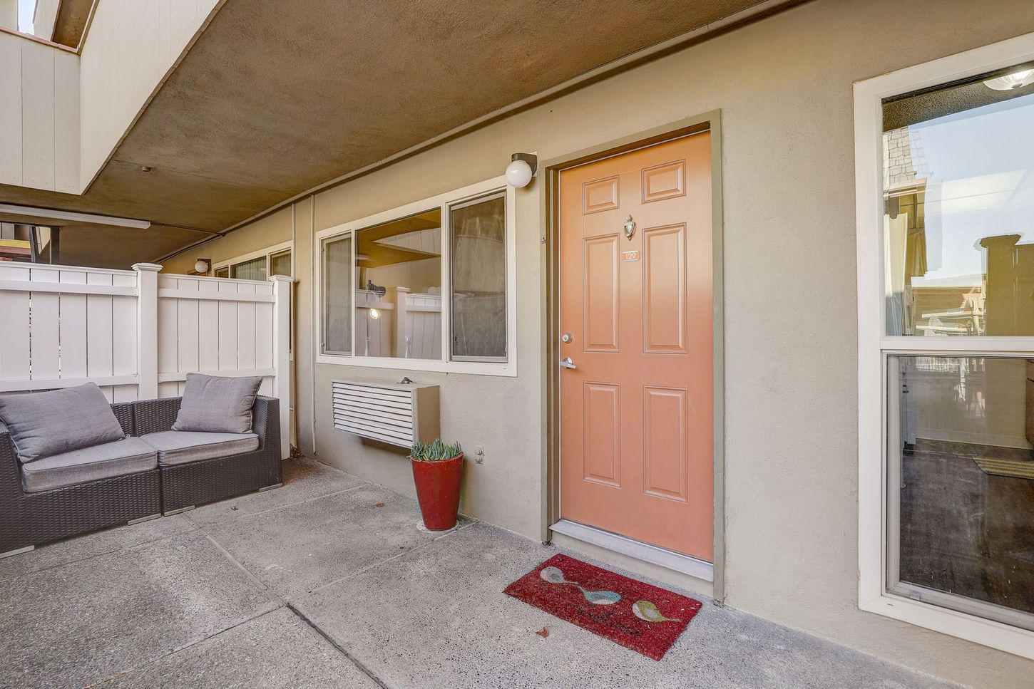 A house with a red door and a couch in front of it.