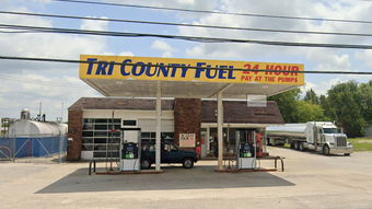 A tri county fuel 24 hour gas station with a truck parked in front of it