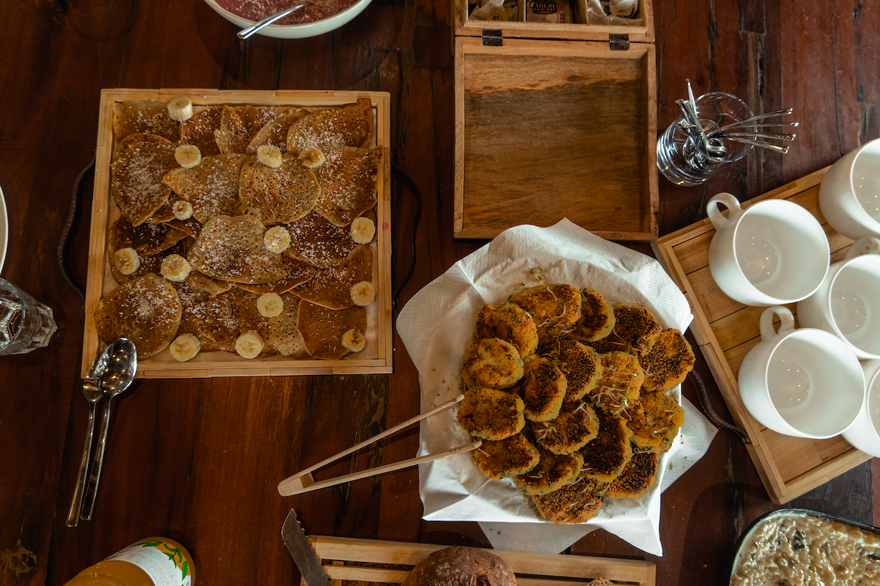 Une table en bois surmontée d'assiettes de nourriture et de tasses.