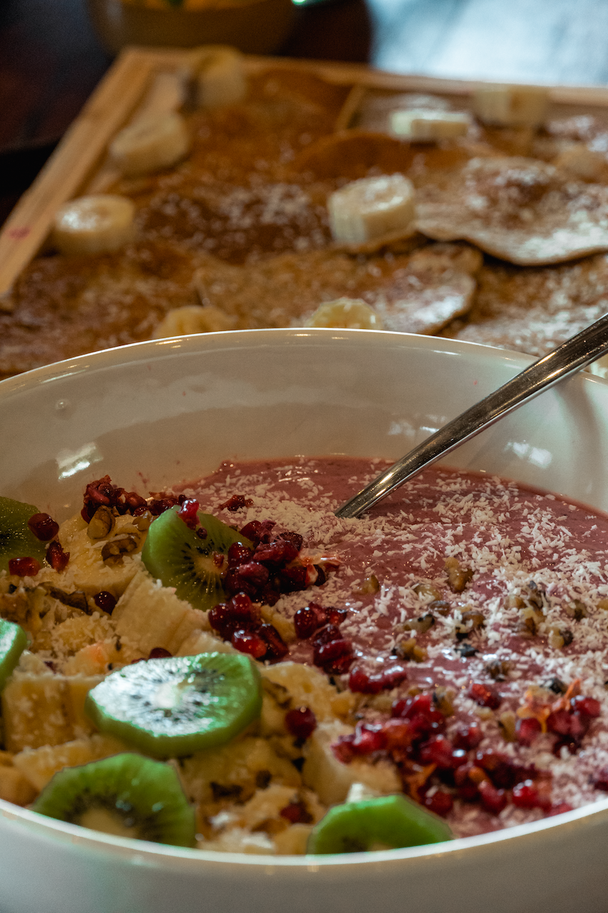 Un bol de nourriture avec une cuillère est sur une table.