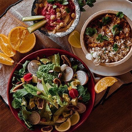 Une table garnie de bols de nourriture et d'une salade, nourriture de la retraite de Yoga au Portugal