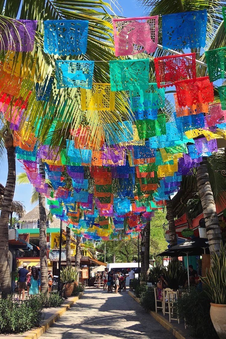 Une rangée de drapeaux en papier colorés suspendus au plafond d'une rue dans Sayulita, le village de la retraite