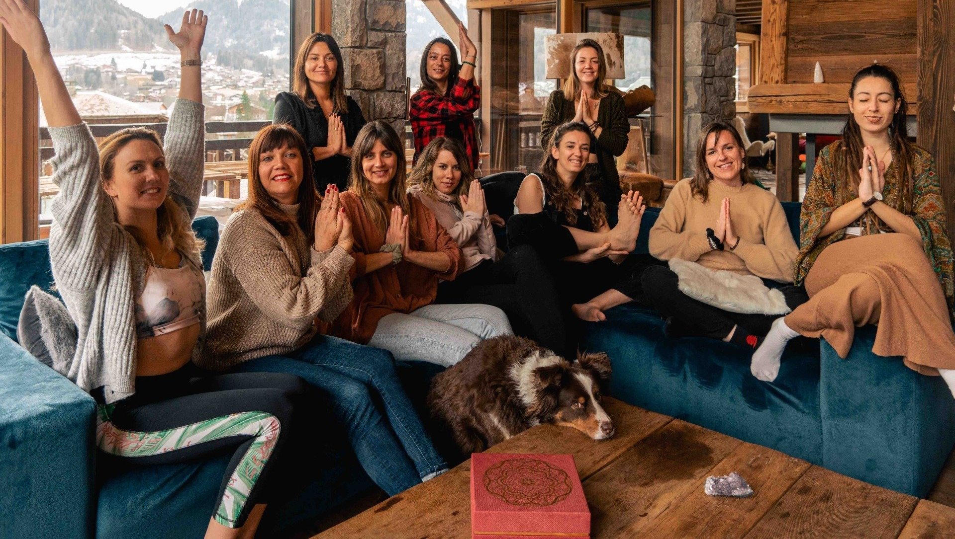 Des yogis sont assises sur un canapé avec un chien lors de la retraite de Yoga et Ski dans les alpes.