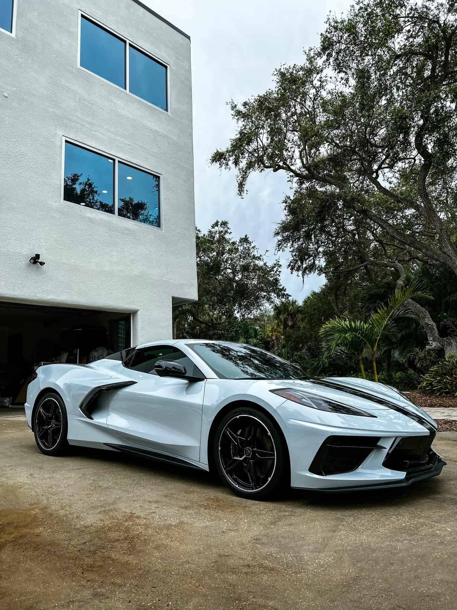 a Ceramic Coated White 2022 Chevrolet C8 Corvette Stingray surrounded by trees with a mansion behind it in Merritt Island, FL