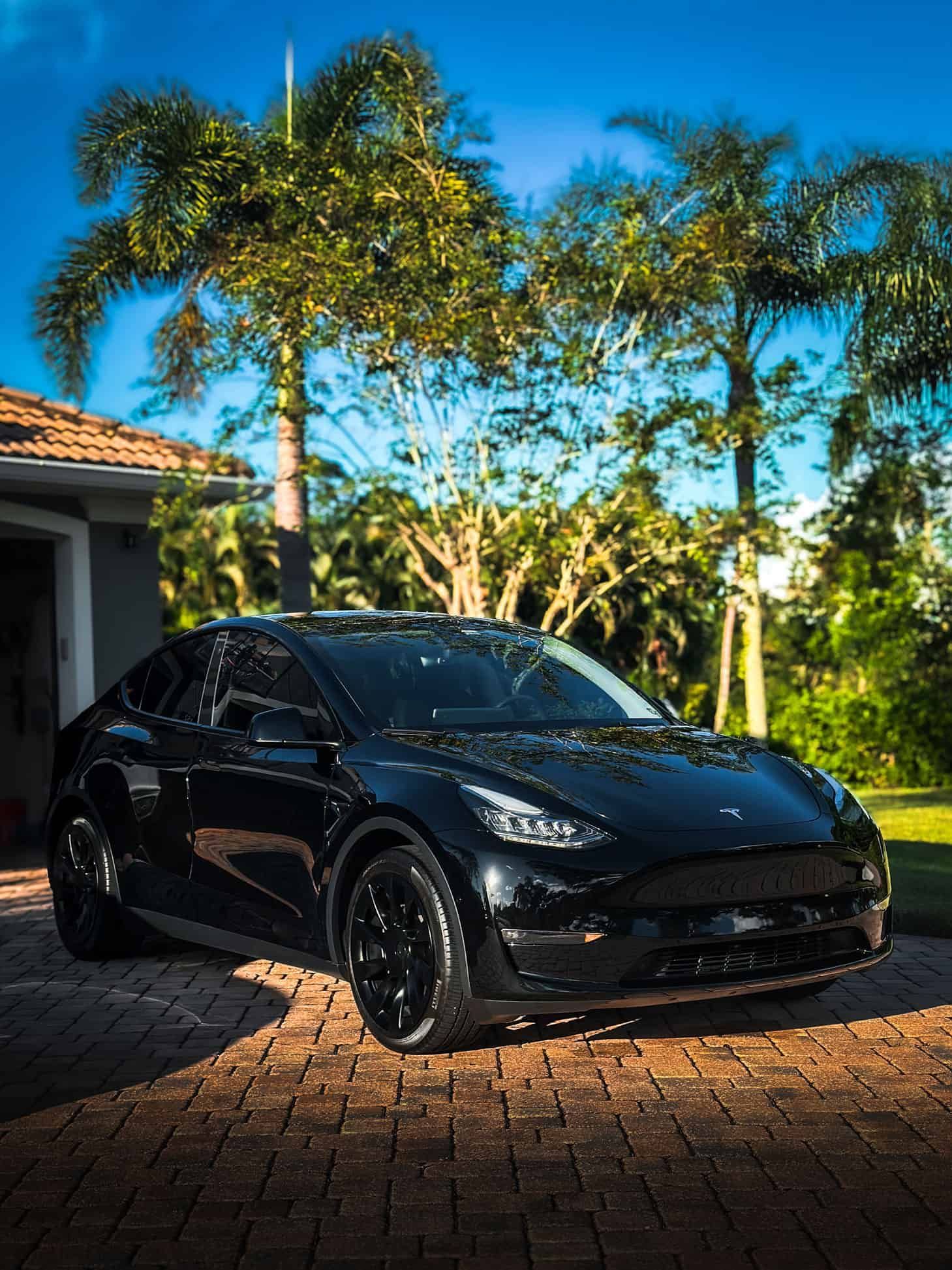 a Black 2022 Tesla Model Y after getting a Full Reset detail in front of a high-end home in Viera, FL