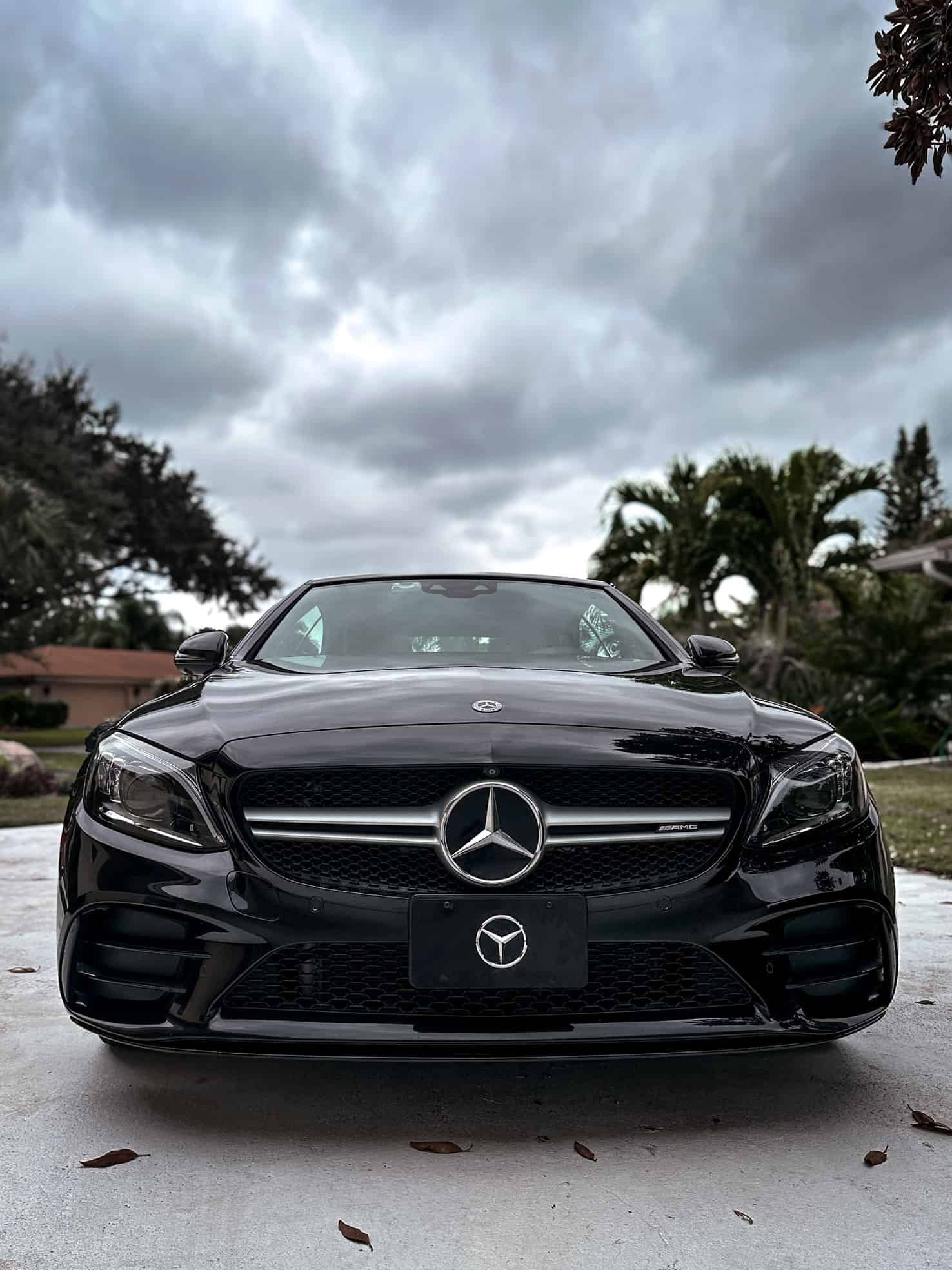 The front end of a Black Mercedes C43 AMG with Ceramic Coated paint, wheels, Calipers, and glass by System X
