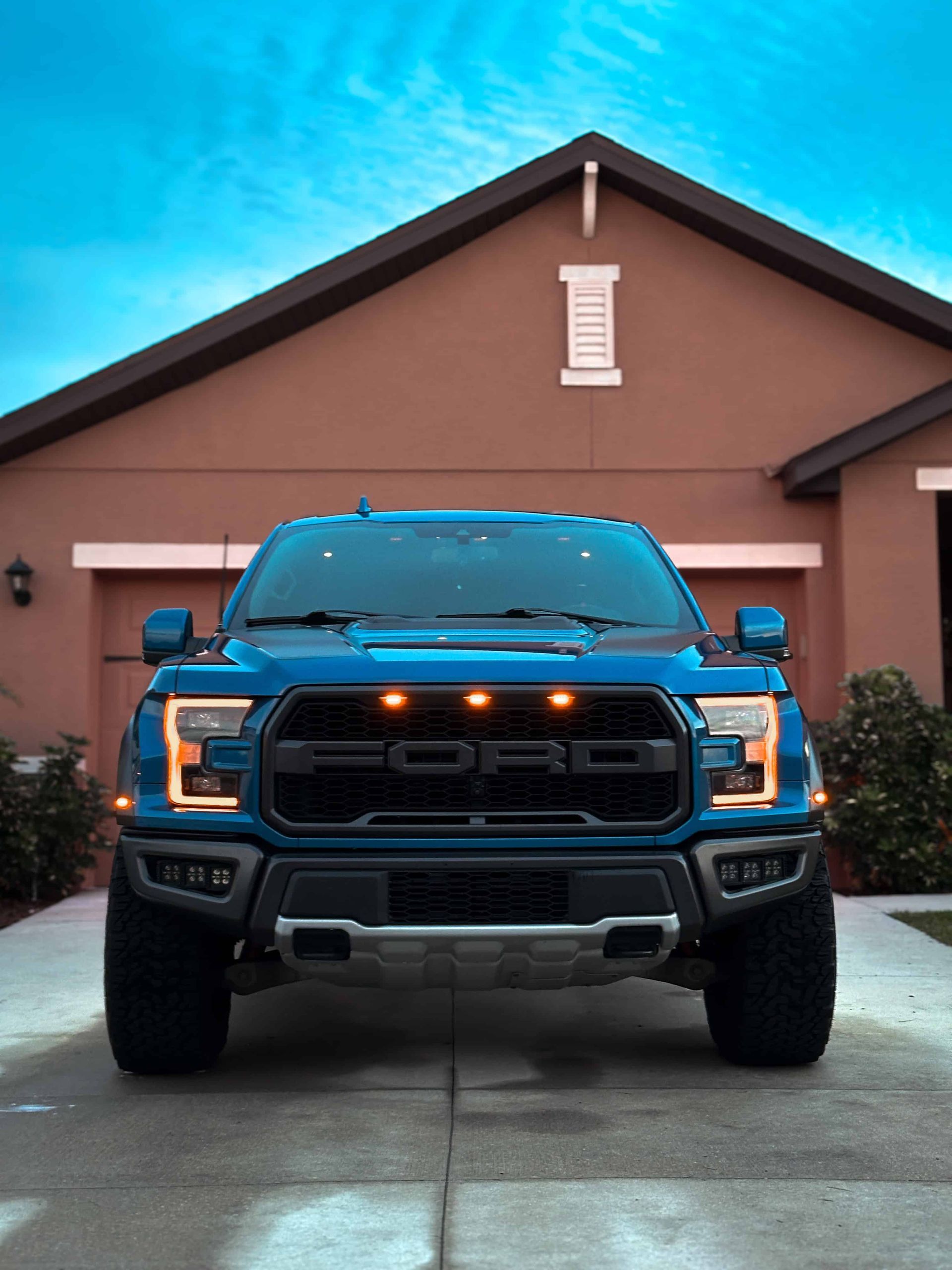 The front end of a 2019 Blue Ford Raptor after receiving a full interior  detail and ceramic coating during blue hour