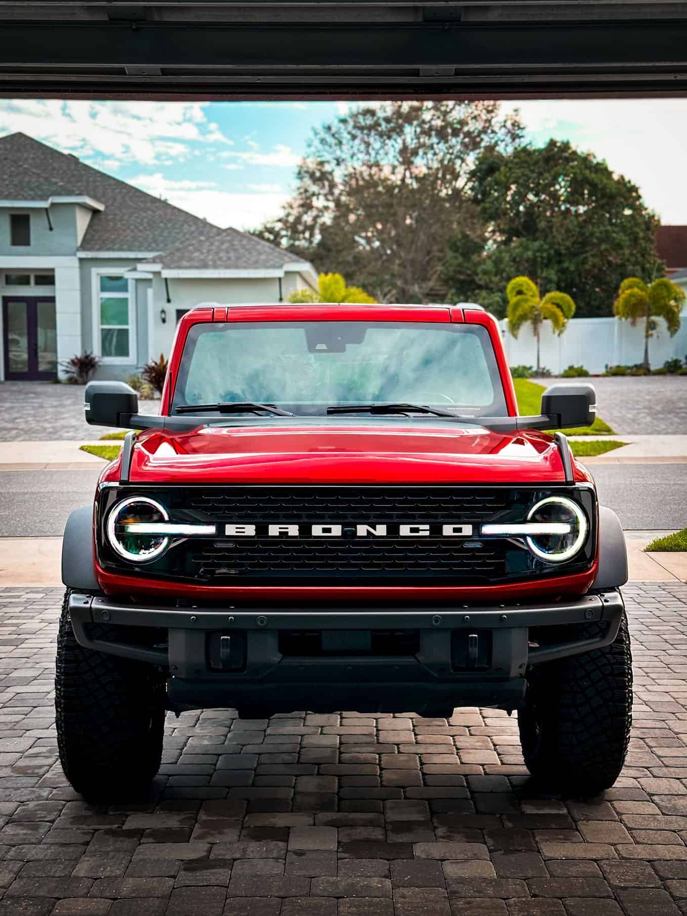 a freshly detailed Red 2021 Ford Bronco front end with small palm trees in the back in Merritt Island, FL