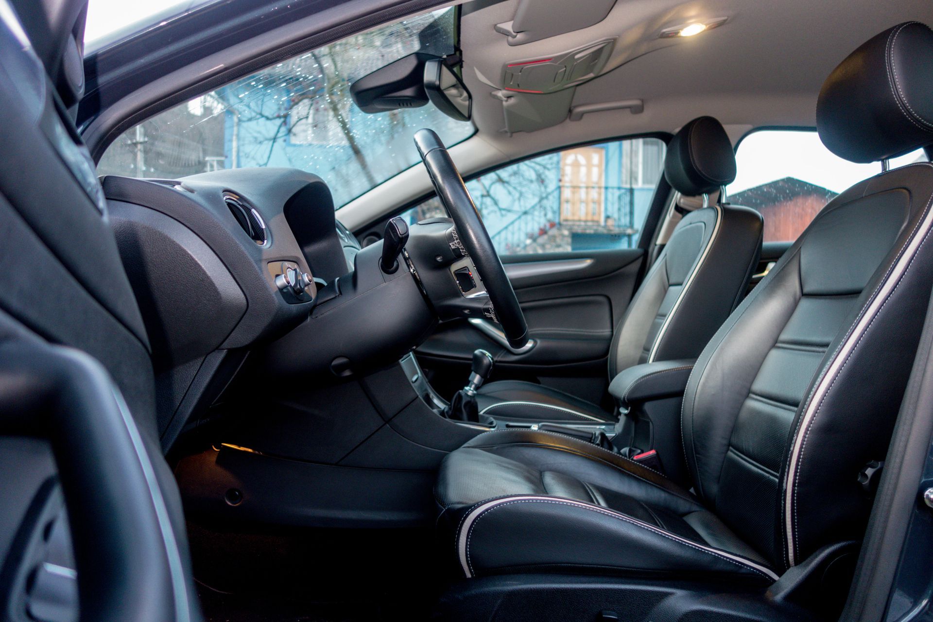 Close up view of perforated black leather car interior. Manual transmission. Interior detail. Modern car, comfortable seats.