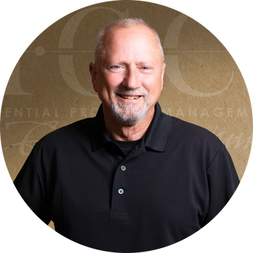Smiling man with gray hair and beard, wearing a black polo shirt, against a background with text.
