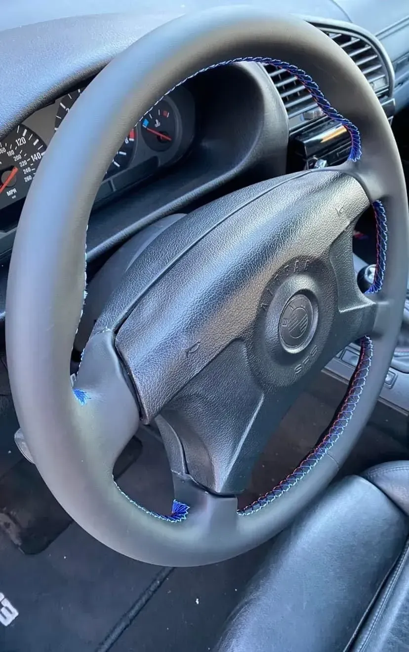 A close up of a steering wheel in a car.