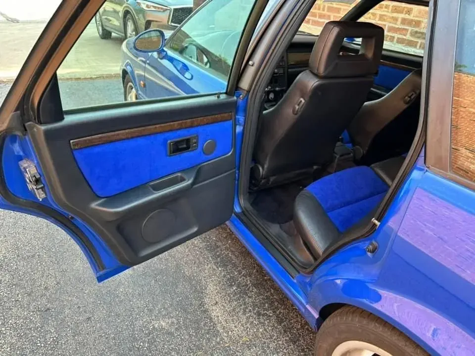 The inside of a blue car with the door open