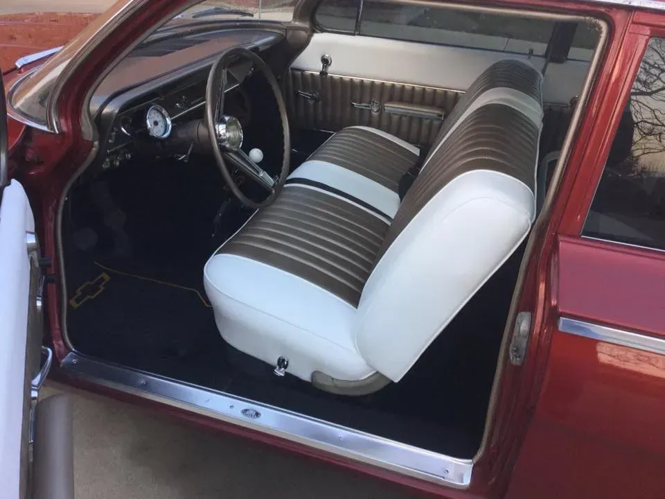 A red car with brown and white seats and a steering wheel
