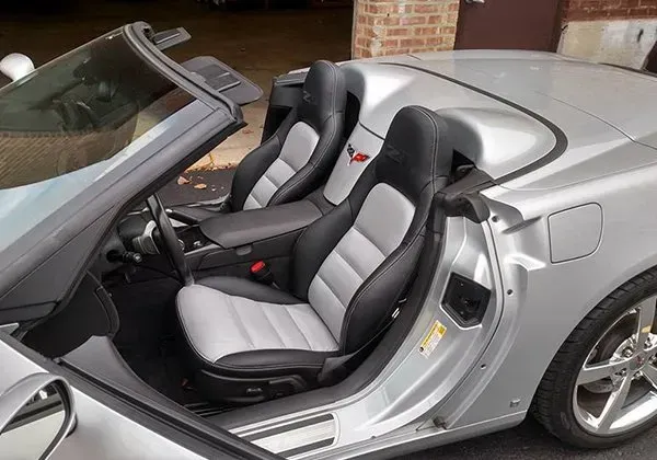 A silver convertible sports car with the top down