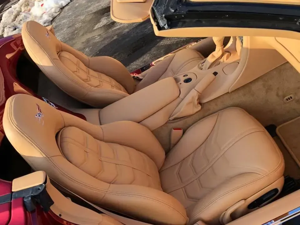 The inside of a red car with tan leather seats