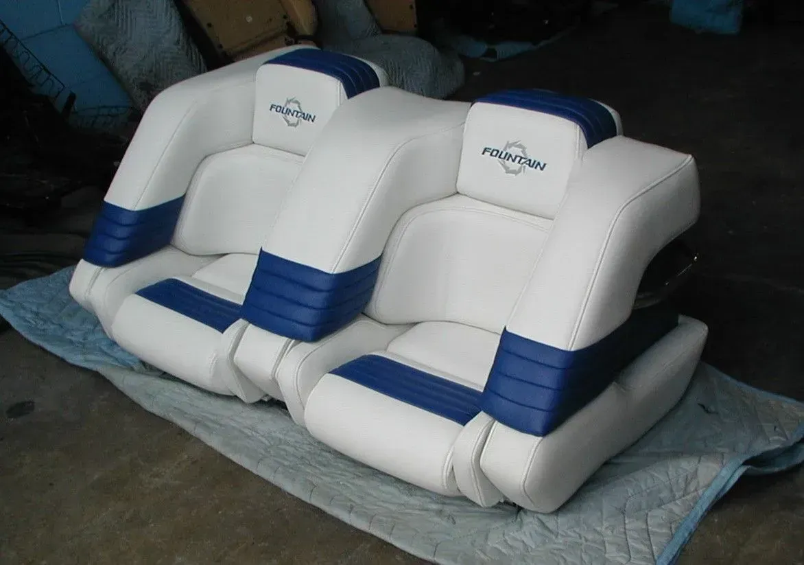 A pair of white and blue boat seats with the word raymarine on the back