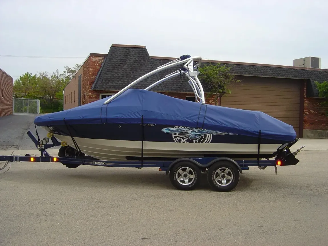 A boat on a trailer with a blue cover on it