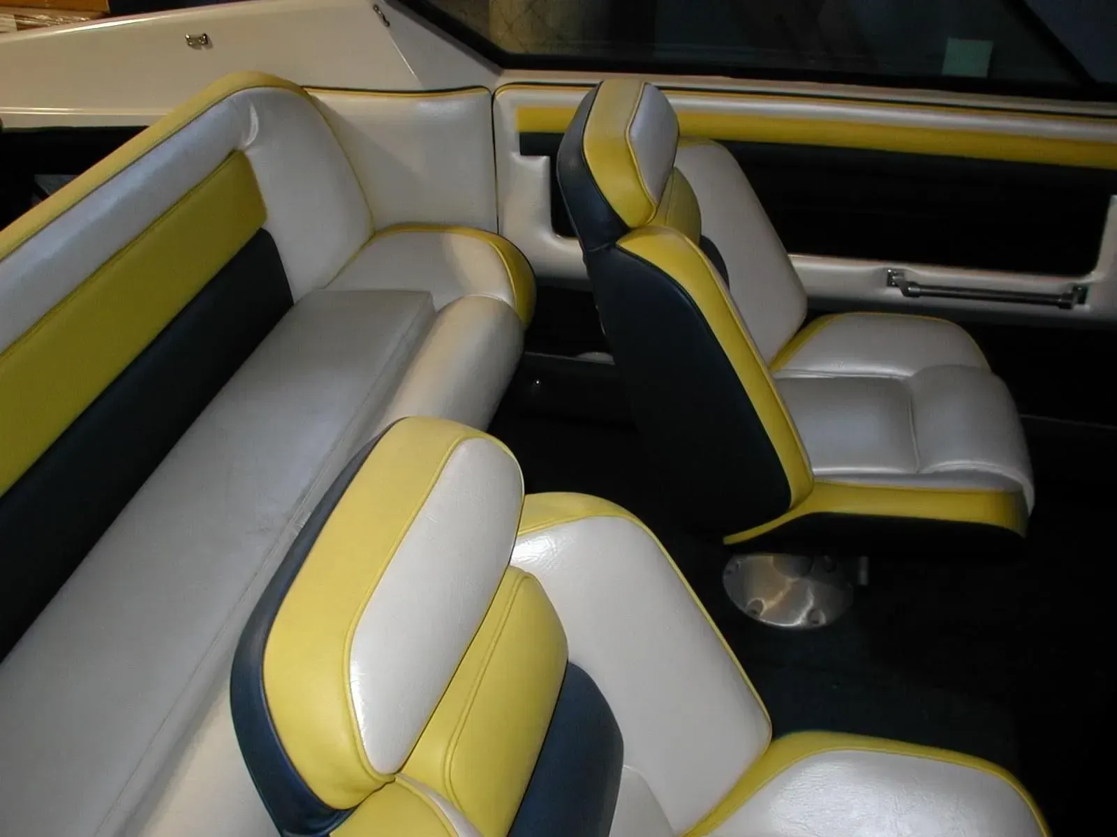 The inside of a boat with yellow and white seats