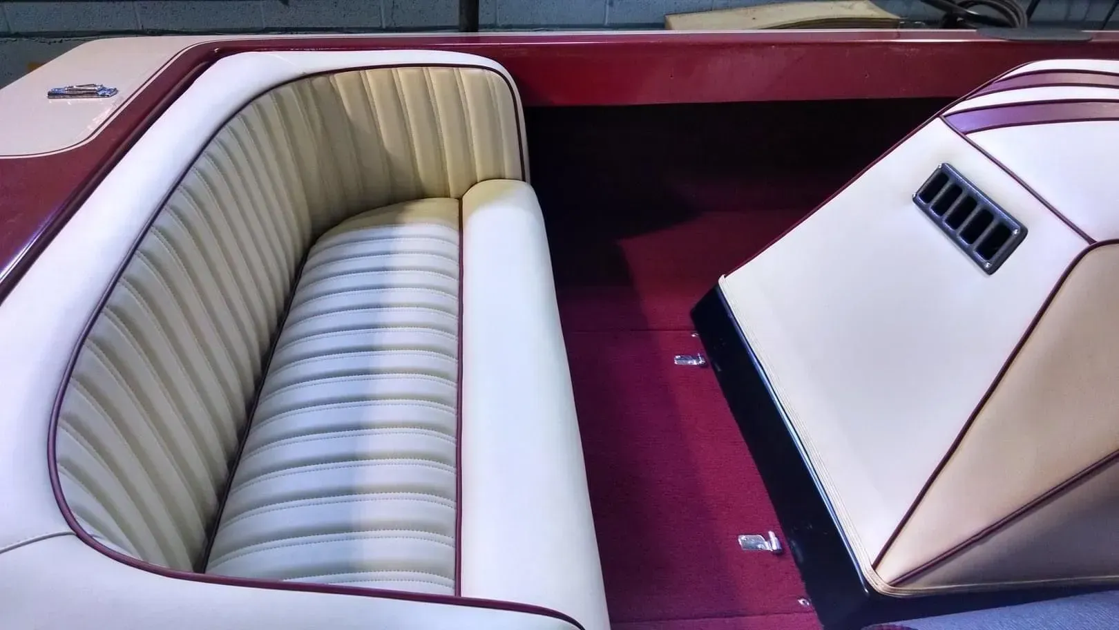 A red and white boat with a striped seat