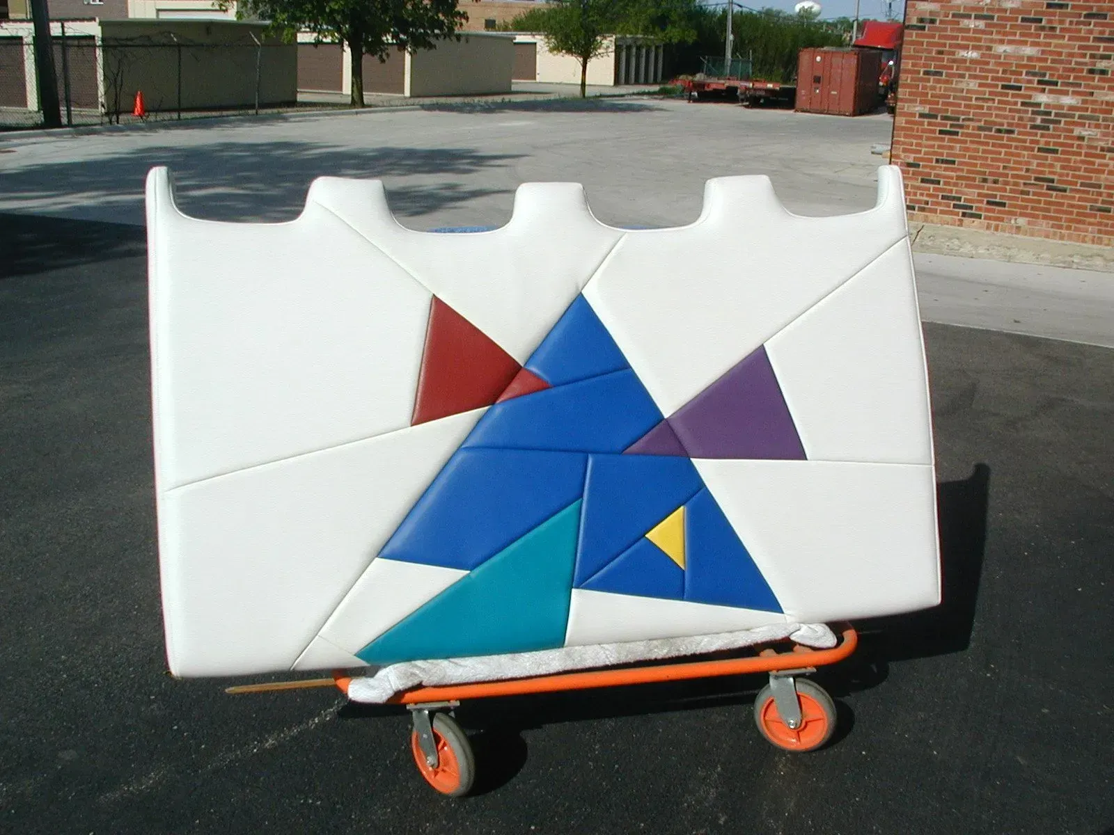 A white block with colorful triangles on it is on a cart