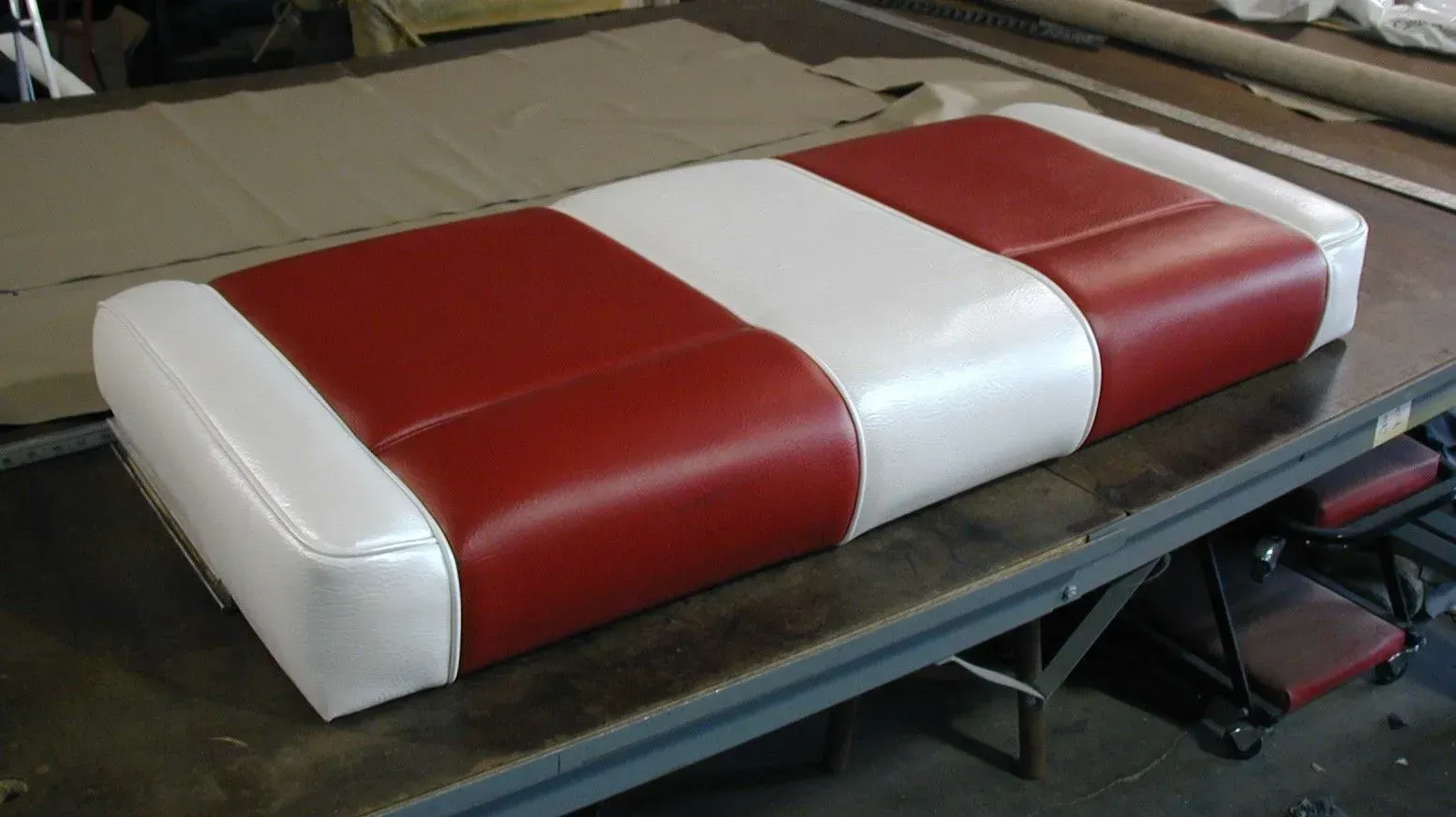 A red and white cushion is sitting on a table.