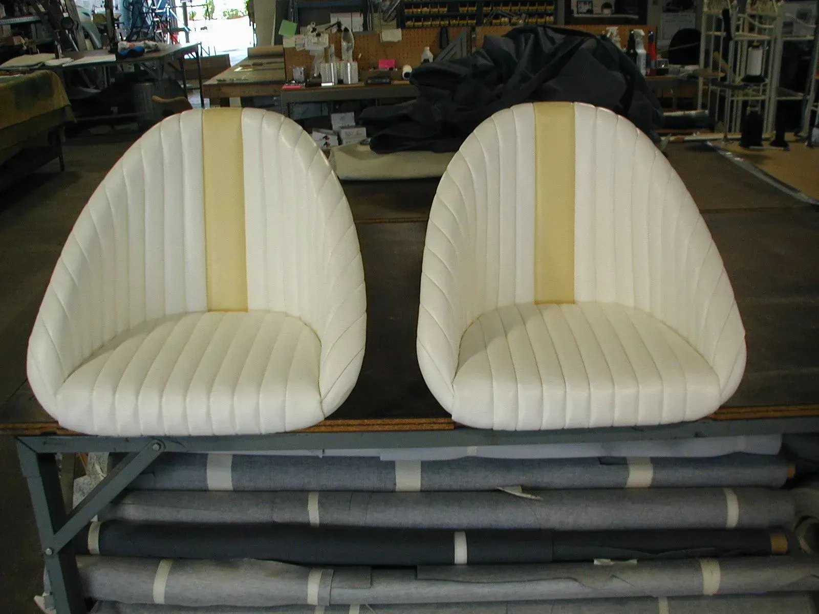 Two white chairs with yellow stripes sit on a table