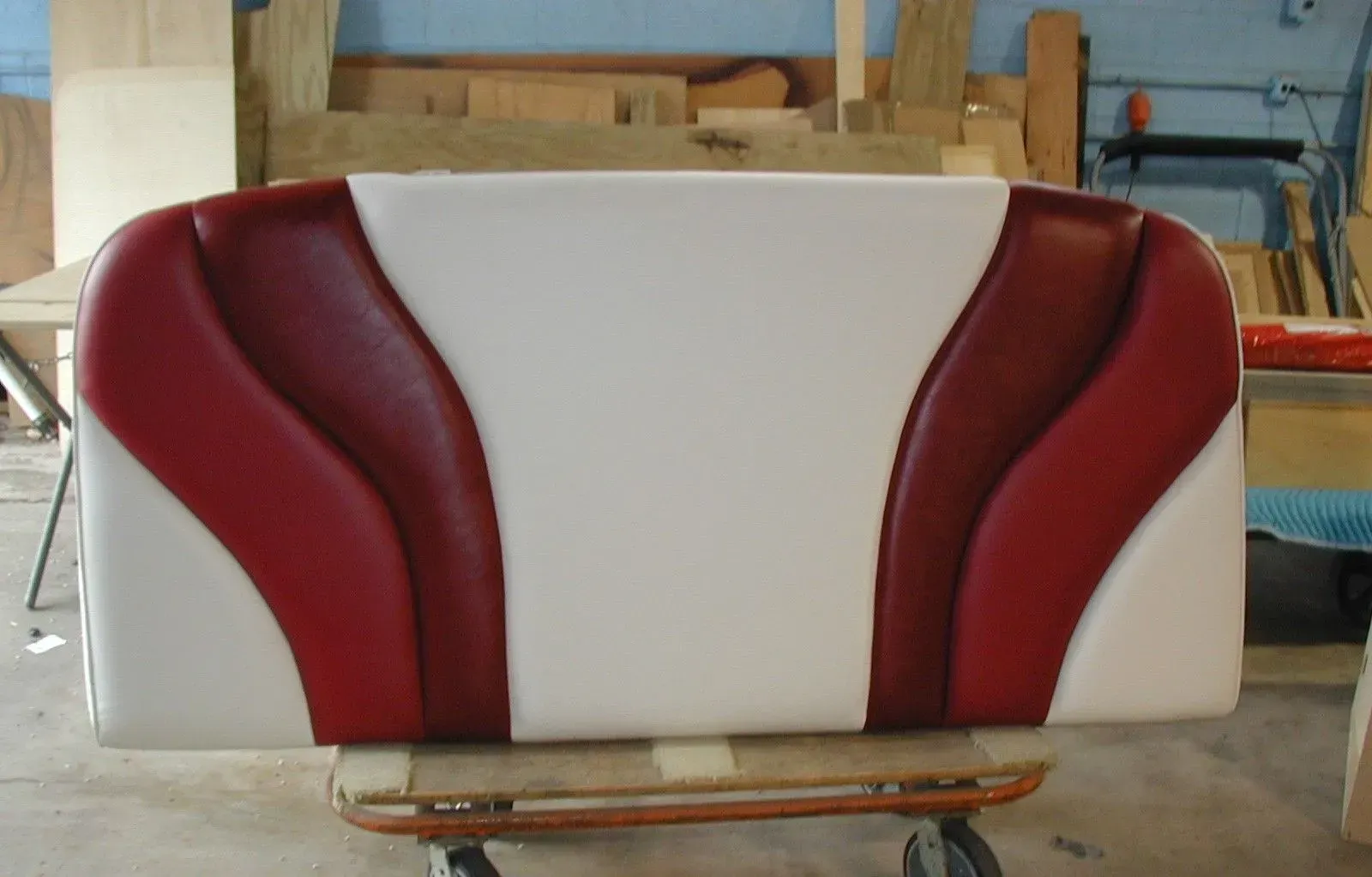 A red and white couch is sitting on a cart