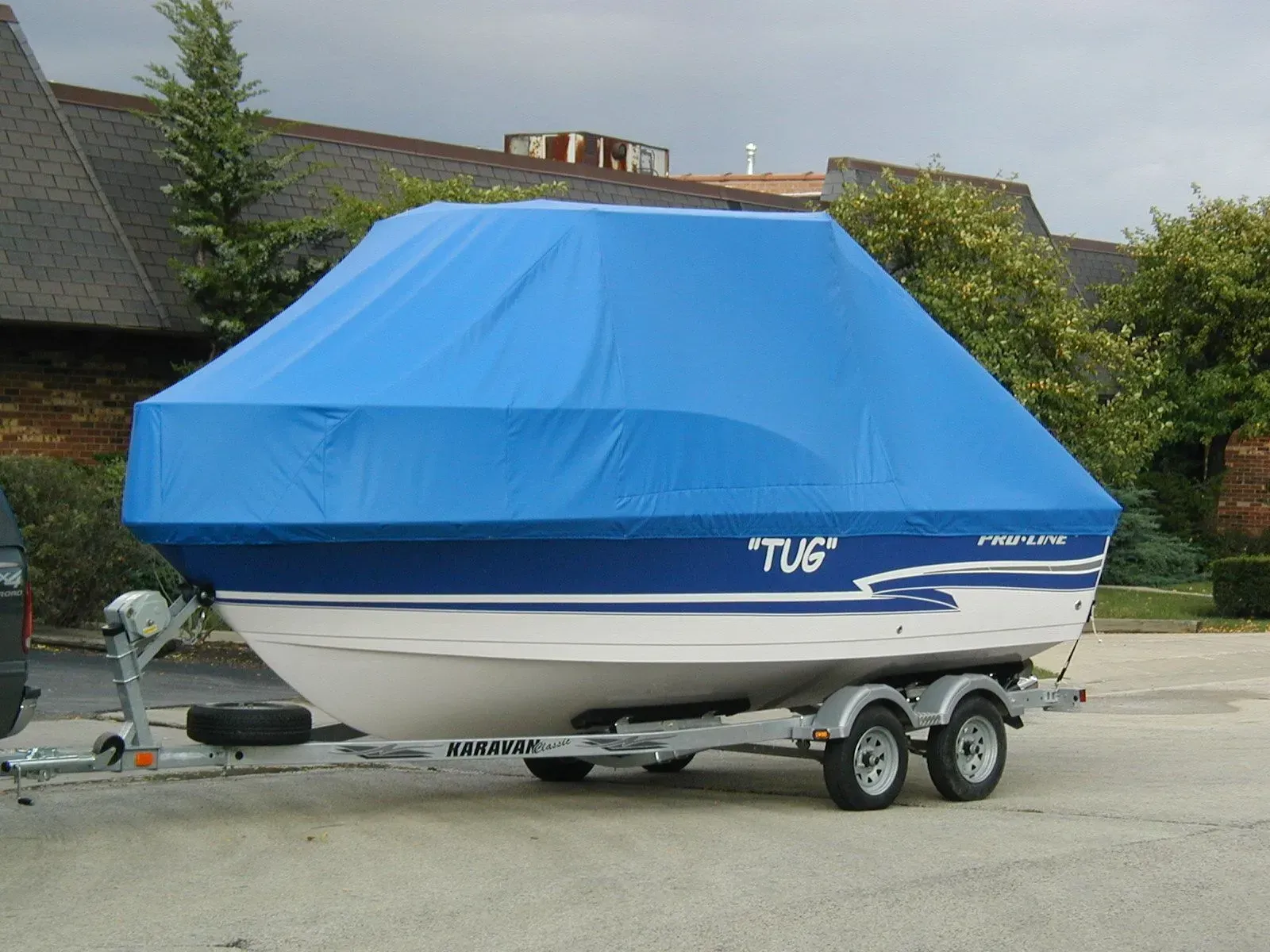 A boat on a trailer with a blue cover that says