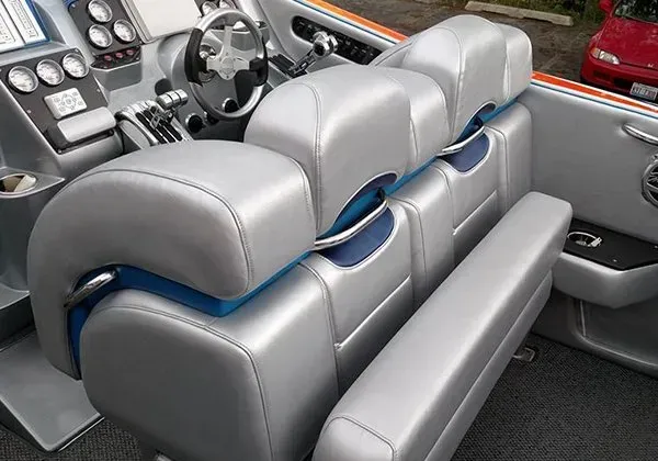The interior of a boat with a steering wheel and seats
