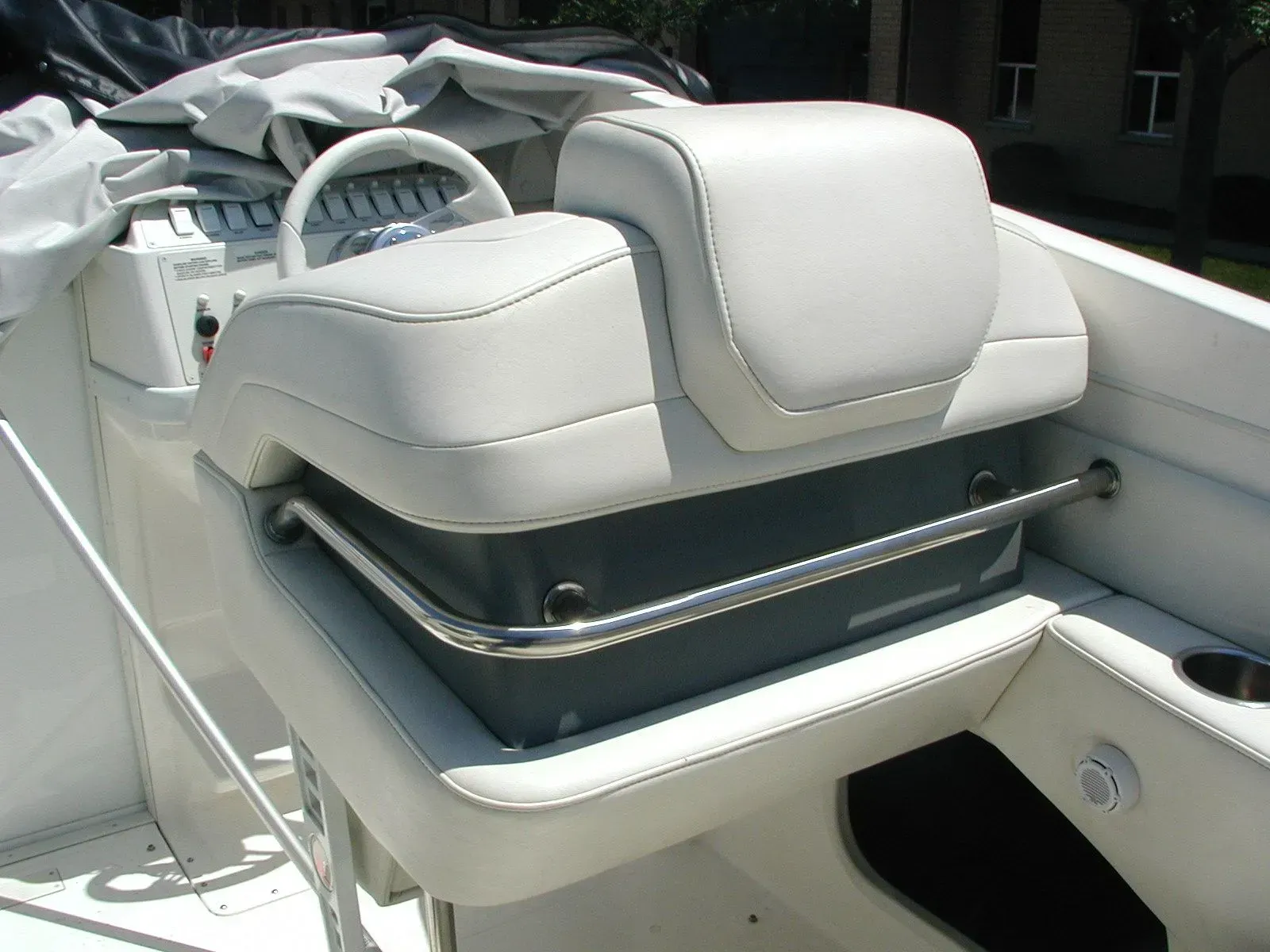 A boat with a white seat and steering wheel