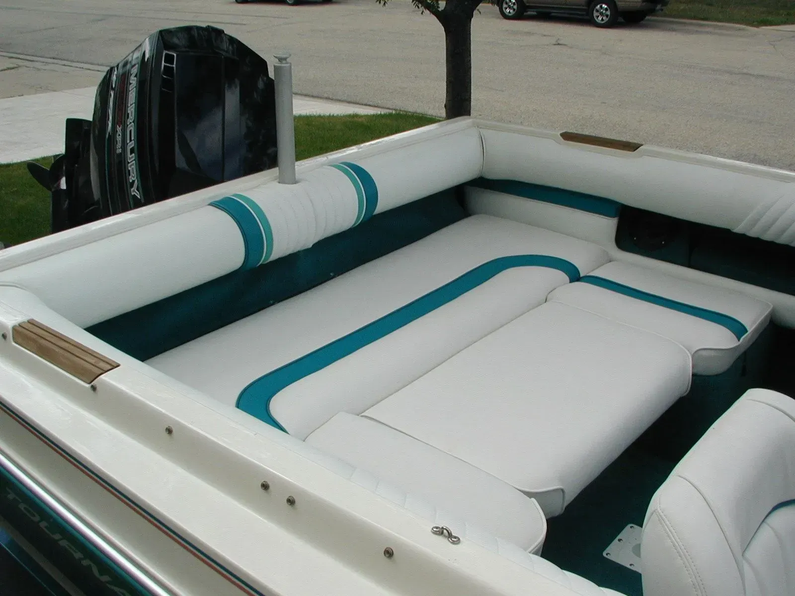 A white and blue boat with a mercury outboard motor
