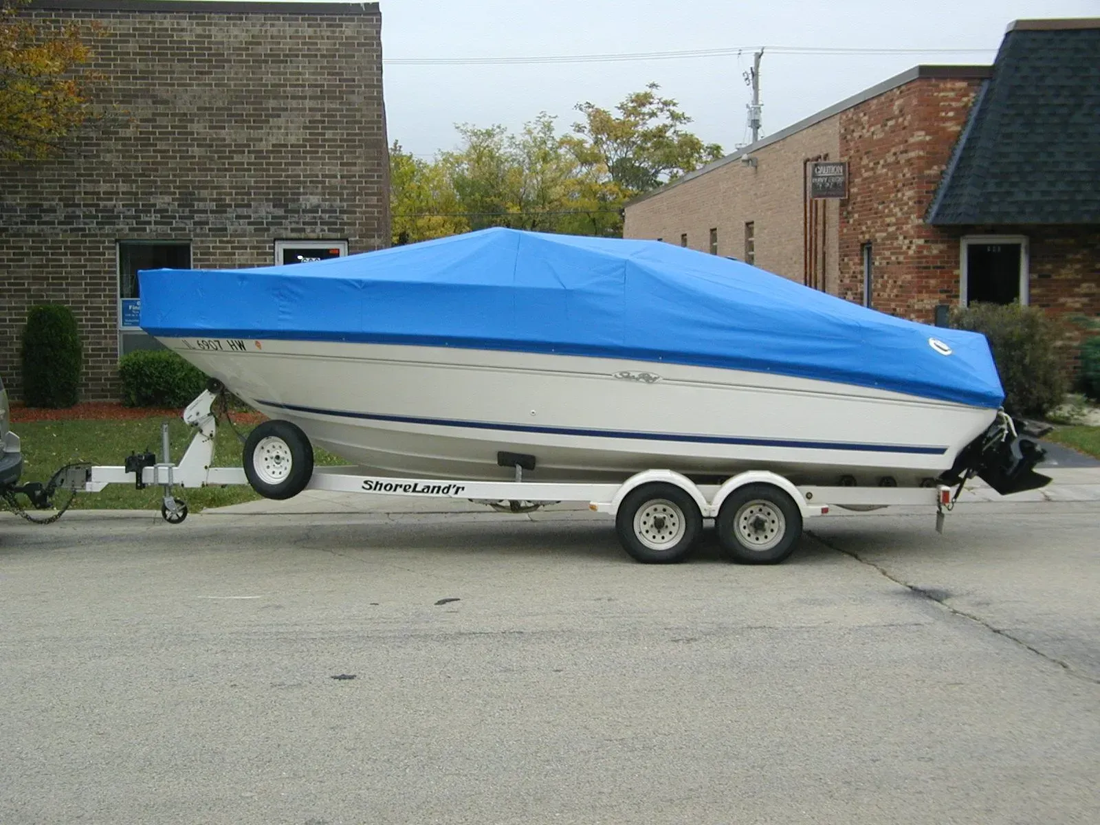A boat on a trailer with a blue cover on it