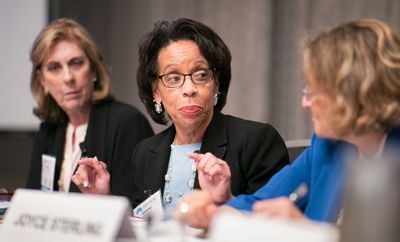 Three women seated at a table, helping to move the legal system forward.