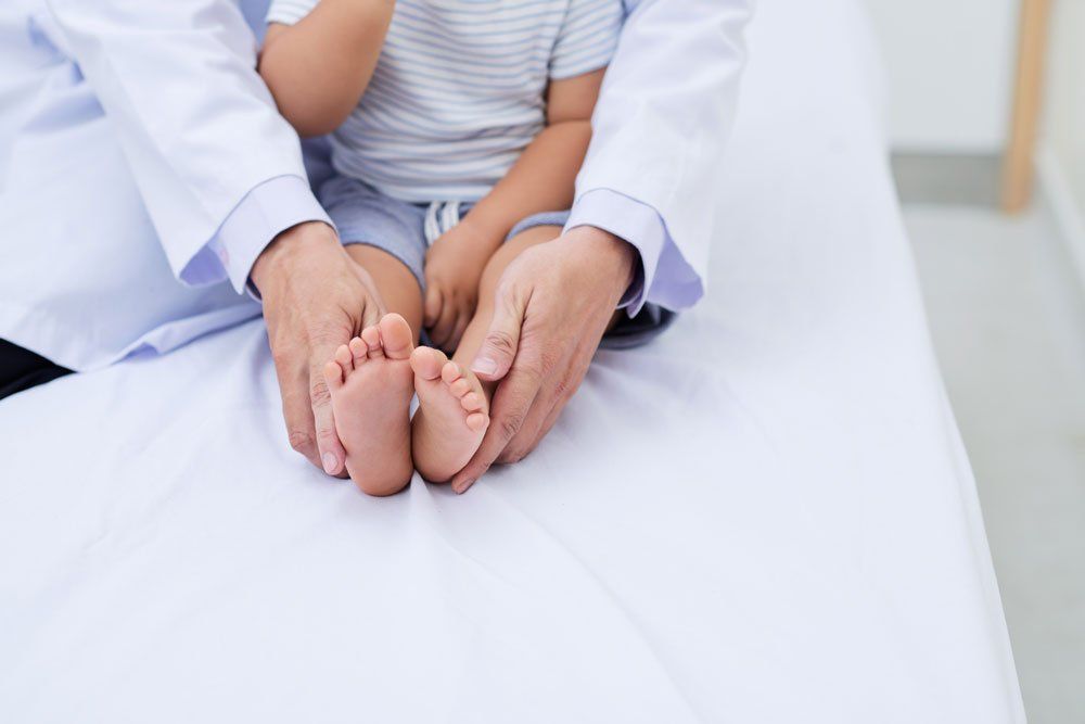 Doctor Holding Child's Feet — Indianapolis, IN — Northeast Foot And Ankle