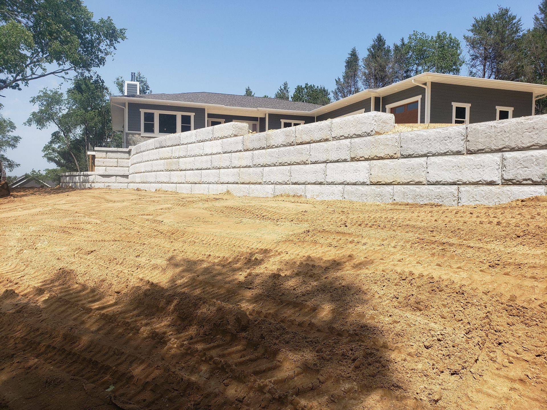 A large house is being built on top of a dirt hill.