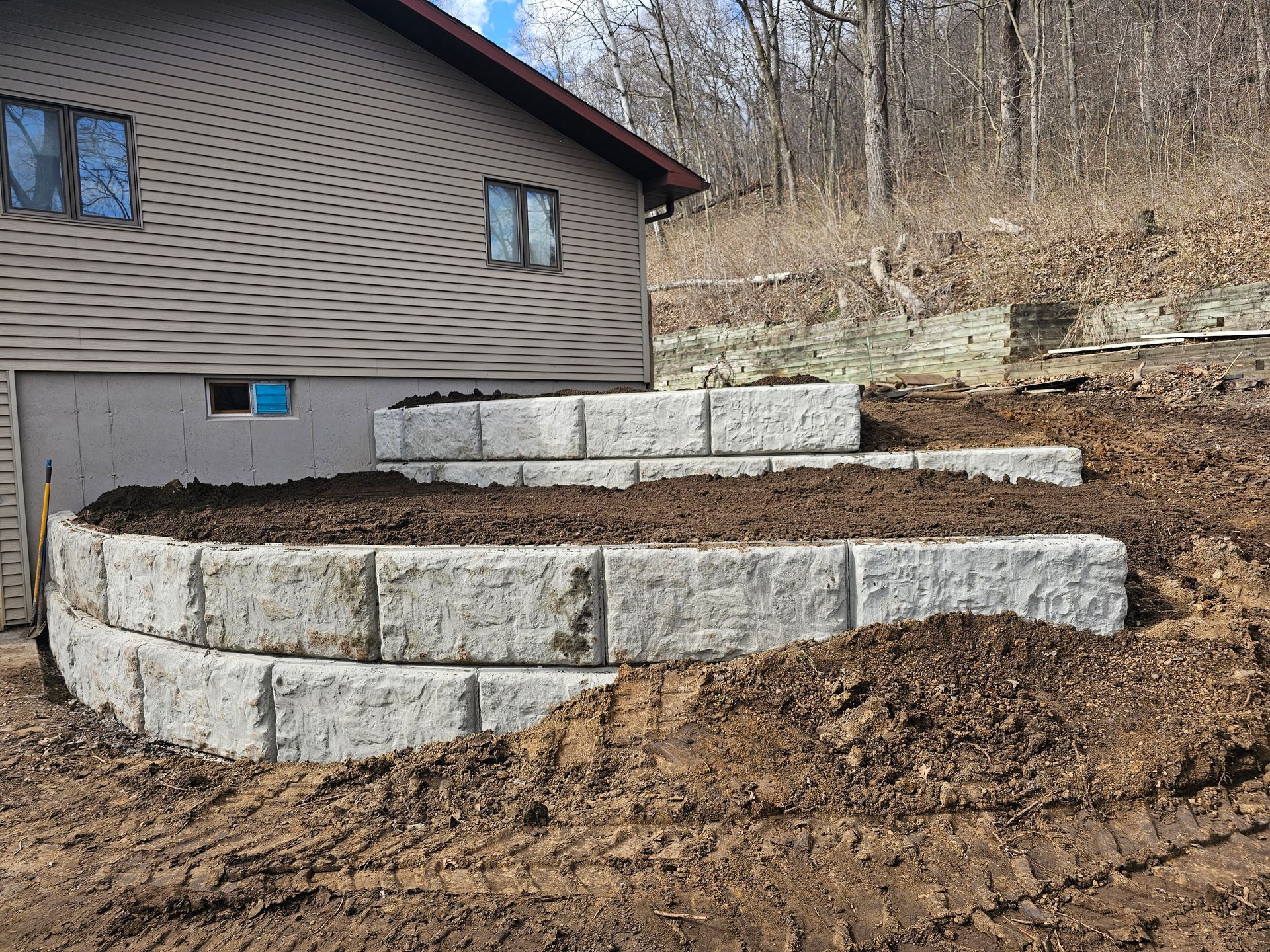 A stone wall is being built in front of a house.