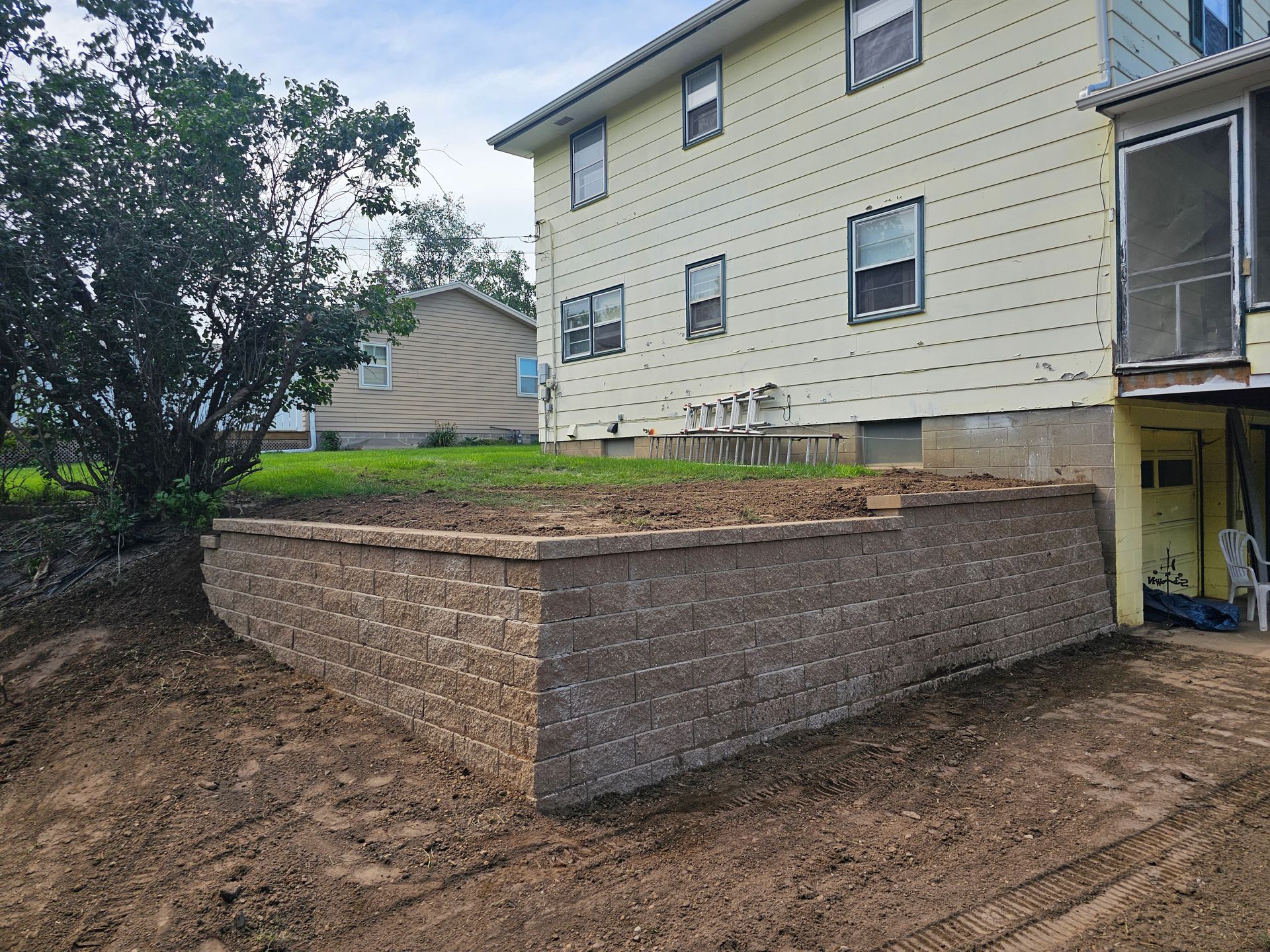 A brick wall is being built in front of a house.